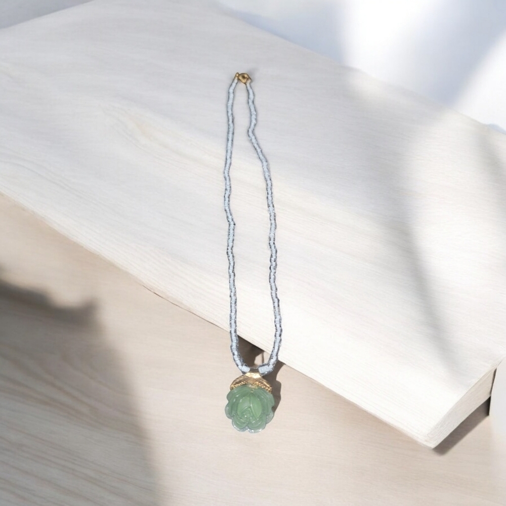 Green flower on a white and silver cord necklace